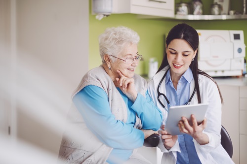 Image d'une dame agee avec un medecin equipe d'une tablette